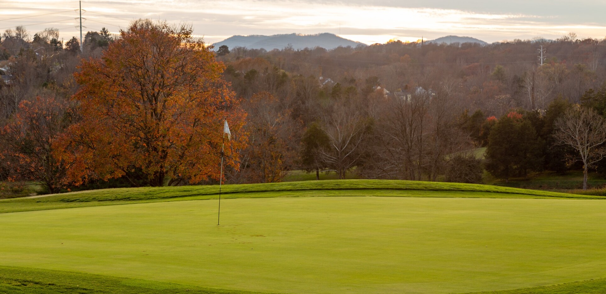 Golf course in fall with flag over hole